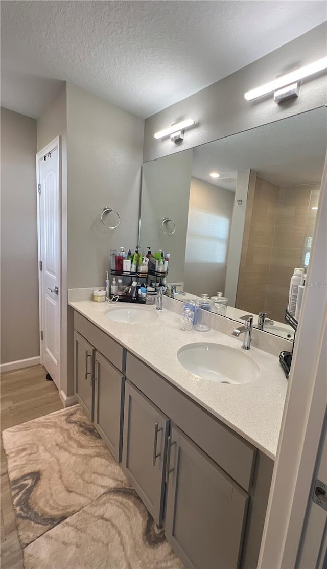 bathroom with vanity, wood-type flooring, and a textured ceiling