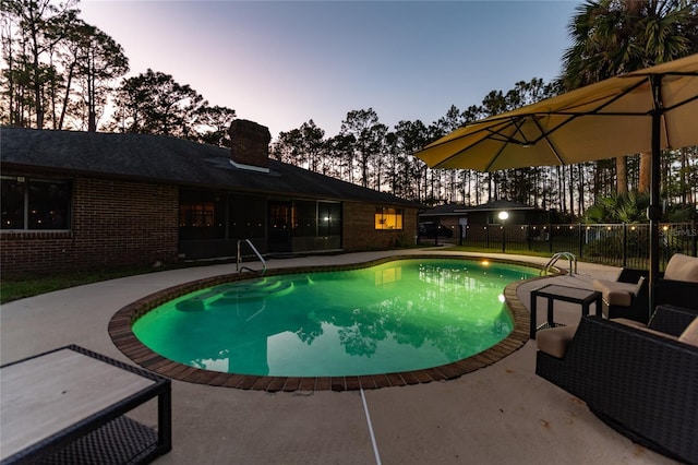 pool at dusk with a patio