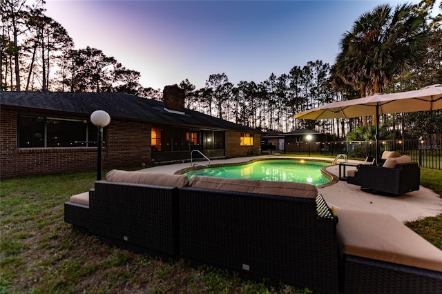 pool at dusk with a patio and outdoor lounge area