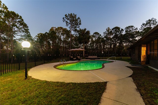 pool at dusk featuring a patio