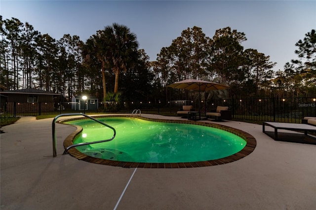 pool at dusk featuring a patio area