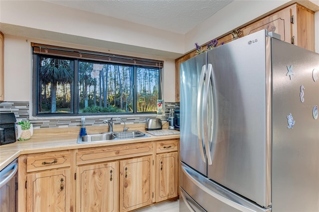 kitchen with tasteful backsplash, sink, stainless steel appliances, and light brown cabinets