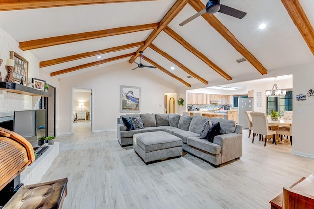 living room with ceiling fan with notable chandelier, high vaulted ceiling, a fireplace, light wood-type flooring, and beam ceiling