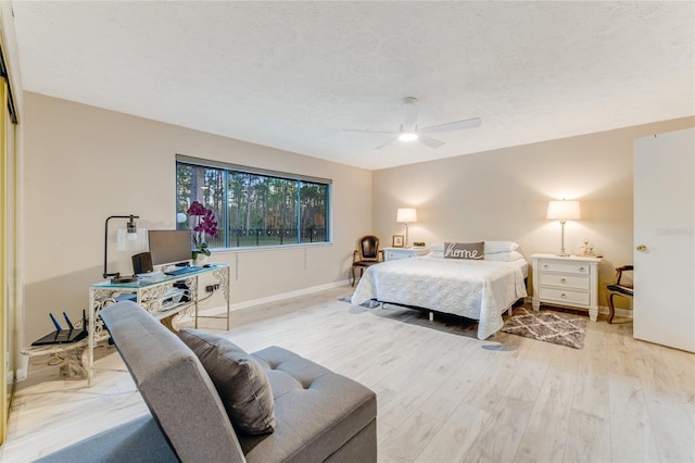 bedroom with ceiling fan, a textured ceiling, and light wood-type flooring