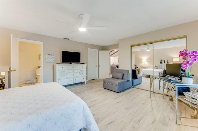 bedroom featuring light hardwood / wood-style floors, a closet, ceiling fan, and ensuite bathroom