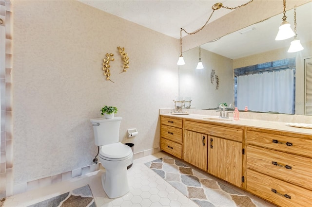 bathroom featuring vanity, tile patterned floors, and toilet