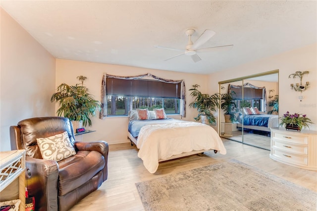 bedroom featuring ceiling fan, light hardwood / wood-style floors, and a closet