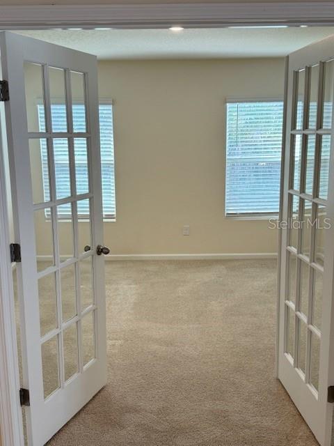 carpeted empty room with french doors