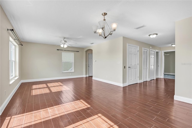 unfurnished room featuring ceiling fan with notable chandelier and dark hardwood / wood-style floors