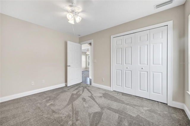 unfurnished bedroom with ceiling fan, a closet, and carpet