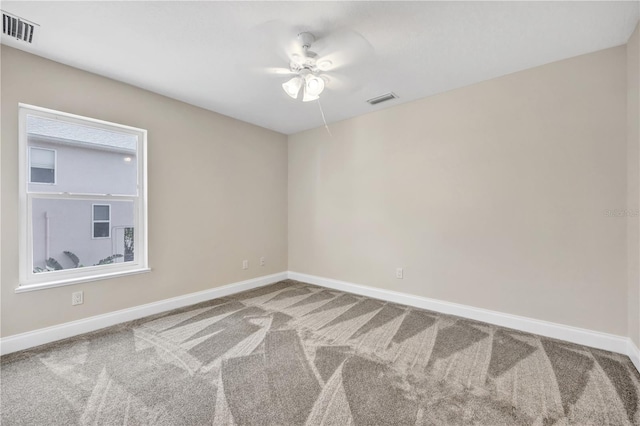 carpeted spare room with ceiling fan