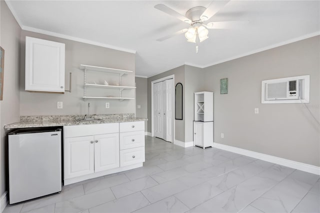 kitchen with white cabinetry, fridge, sink, and ornamental molding