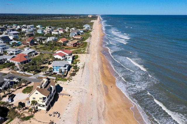 birds eye view of property featuring a water view and a beach view