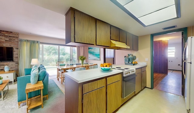 kitchen with white refrigerator, range with electric cooktop, and kitchen peninsula