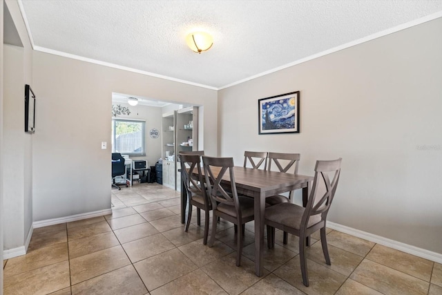 dining room with light tile patterned floors, ornamental molding, and a textured ceiling