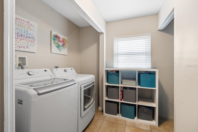 laundry area featuring washing machine and dryer and light tile patterned floors