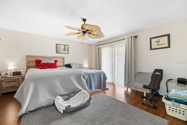 bedroom with ceiling fan, a textured ceiling, and dark hardwood / wood-style flooring