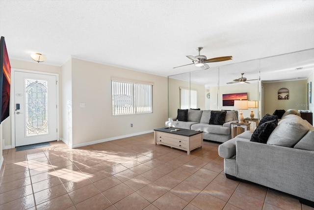 living room featuring tile patterned flooring, ceiling fan, and a textured ceiling