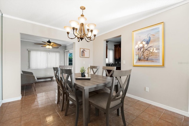 dining area with crown molding, ceiling fan with notable chandelier, and dark tile patterned flooring