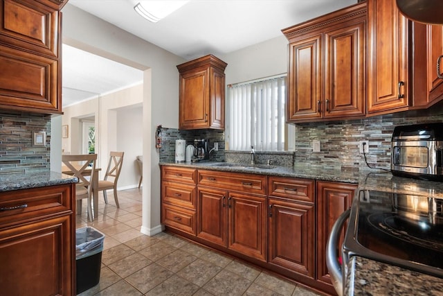 kitchen featuring range with electric stovetop, light tile patterned flooring, sink, backsplash, and dark stone counters