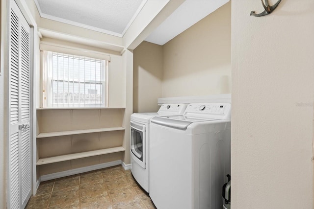 laundry area featuring washing machine and clothes dryer and a textured ceiling