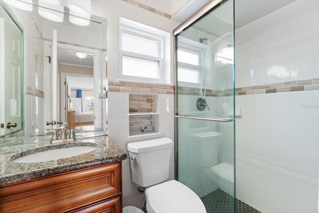 bathroom featuring vanity, tile walls, toilet, and walk in shower