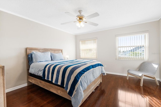 bedroom with multiple windows, dark hardwood / wood-style flooring, ornamental molding, and ceiling fan