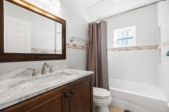 full bathroom with vanity, tile walls, shower / bath combination with curtain, and toilet