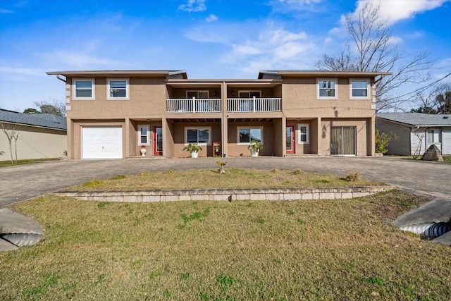 view of front of house with a garage, a balcony, and a front lawn