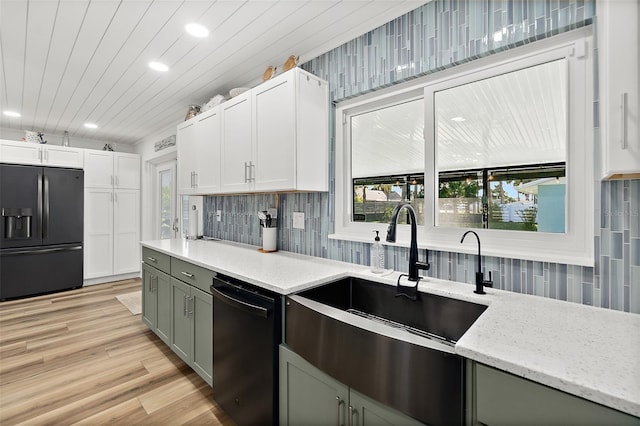 kitchen with sink, backsplash, black appliances, white cabinets, and light wood-type flooring