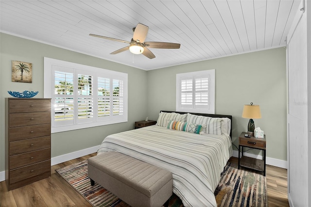 bedroom with hardwood / wood-style flooring, ceiling fan, crown molding, and wooden ceiling