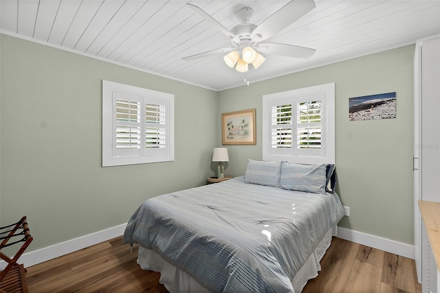 bedroom with hardwood / wood-style flooring, ornamental molding, wooden ceiling, and ceiling fan