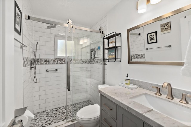 bathroom with a stall shower, vanity, and toilet