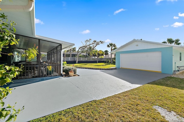 exterior space with a garage, a yard, and a sunroom