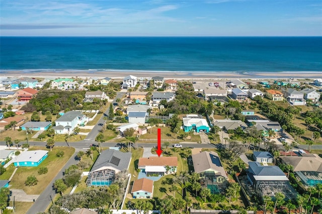 drone / aerial view featuring a water view and a view of the beach