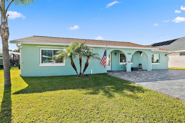 view of front of home with fence, a front lawn, and stucco siding