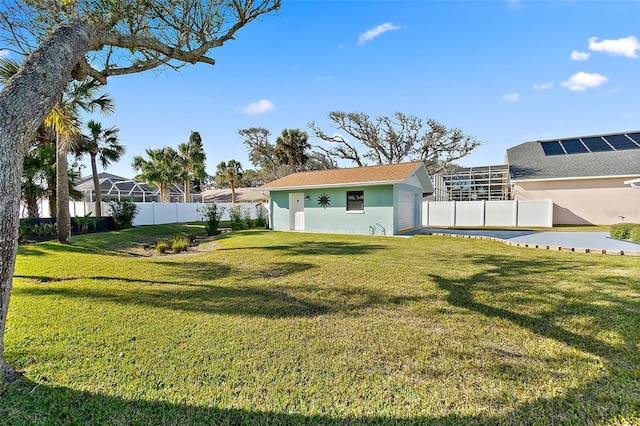 view of yard featuring a garage, an outdoor structure, and a fenced backyard