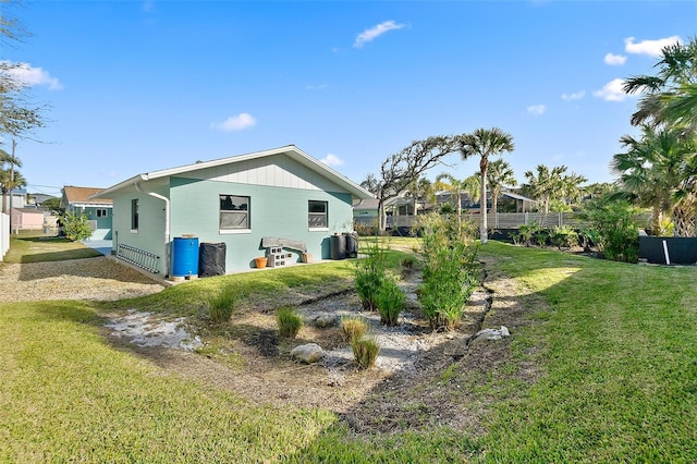 rear view of property with a lawn and fence