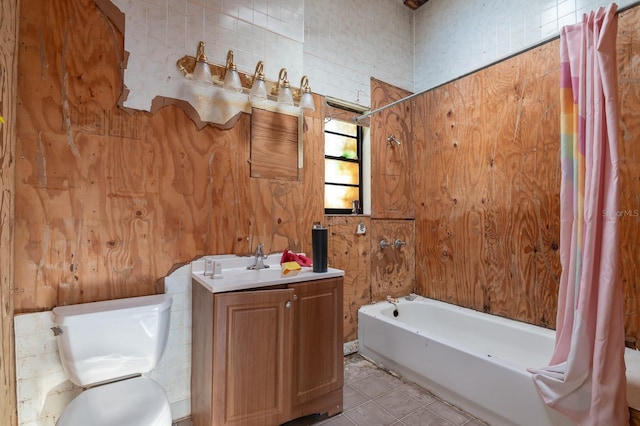 bathroom with tile patterned flooring, vanity, wooden walls, and toilet