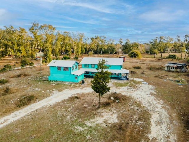 view of subject property with a tree filled landscape