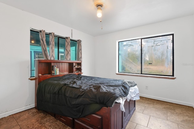 bedroom with baseboards and tile patterned flooring