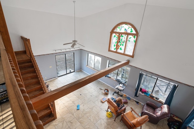 living area with high vaulted ceiling, plenty of natural light, ceiling fan, and tile patterned flooring