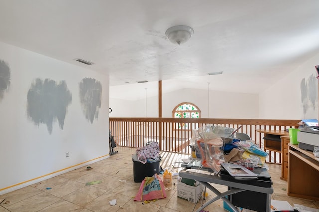 spare room with vaulted ceiling and light tile patterned floors
