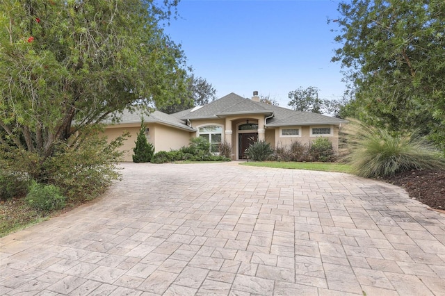 view of front of property featuring a chimney and stucco siding