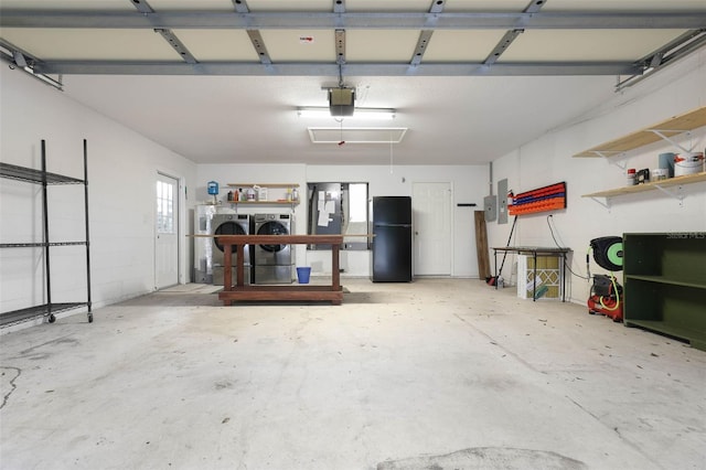 garage featuring washer and dryer, freestanding refrigerator, electric panel, and a garage door opener