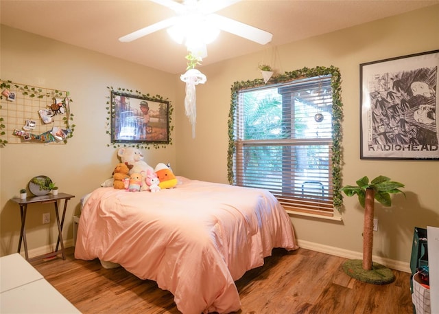 bedroom featuring ceiling fan, baseboards, and wood finished floors