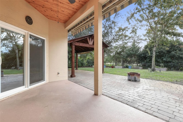 view of patio / terrace featuring an outdoor fire pit, fence, and a ceiling fan