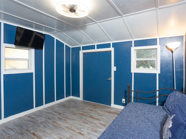 bedroom with lofted ceiling, multiple windows, and wood finished floors