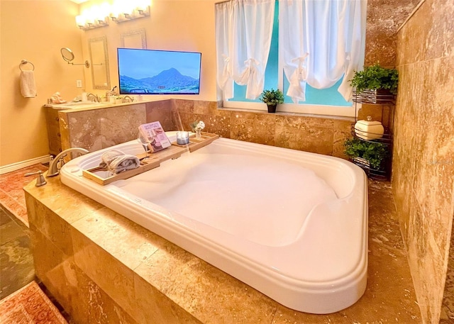 full bathroom with a relaxing tiled tub and baseboards