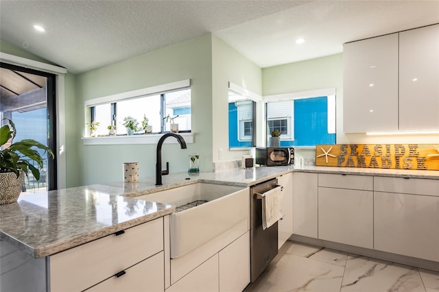 kitchen featuring sink, a textured ceiling, dishwasher, light stone countertops, and white cabinets